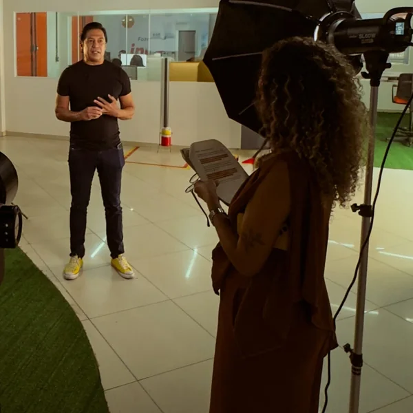 Set de gravação no estúdio: o apresentador e a diretora com o roteiro